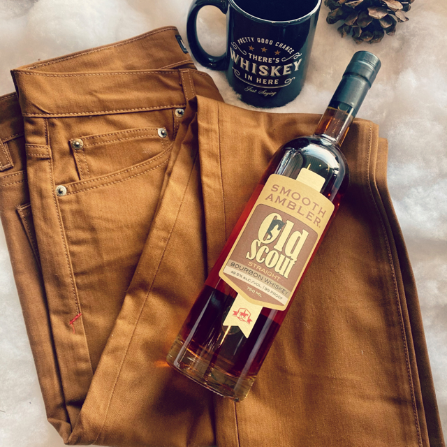 Marc Nelson whiskey stained denim next to a bottle of Smooth Ambler bourbon whiskey.