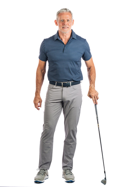 A model posing in a navy striped golf polo and grey pants, holding a golf club.