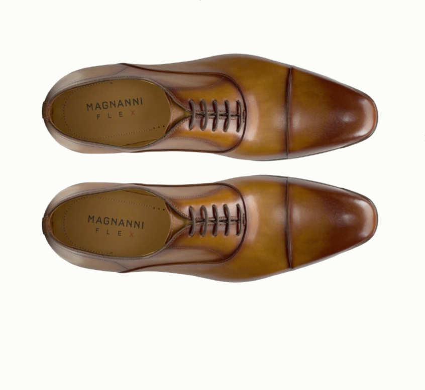 A pair of brown leather Magnanni Flex dress shoes, viewed from above, showing cap toe and laces on a white background.