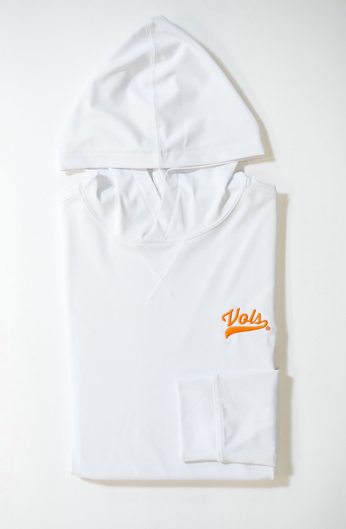 A white hooded sweatshirt neatly folded on a white surface, featuring the word Vols in orange script on the left chest area.