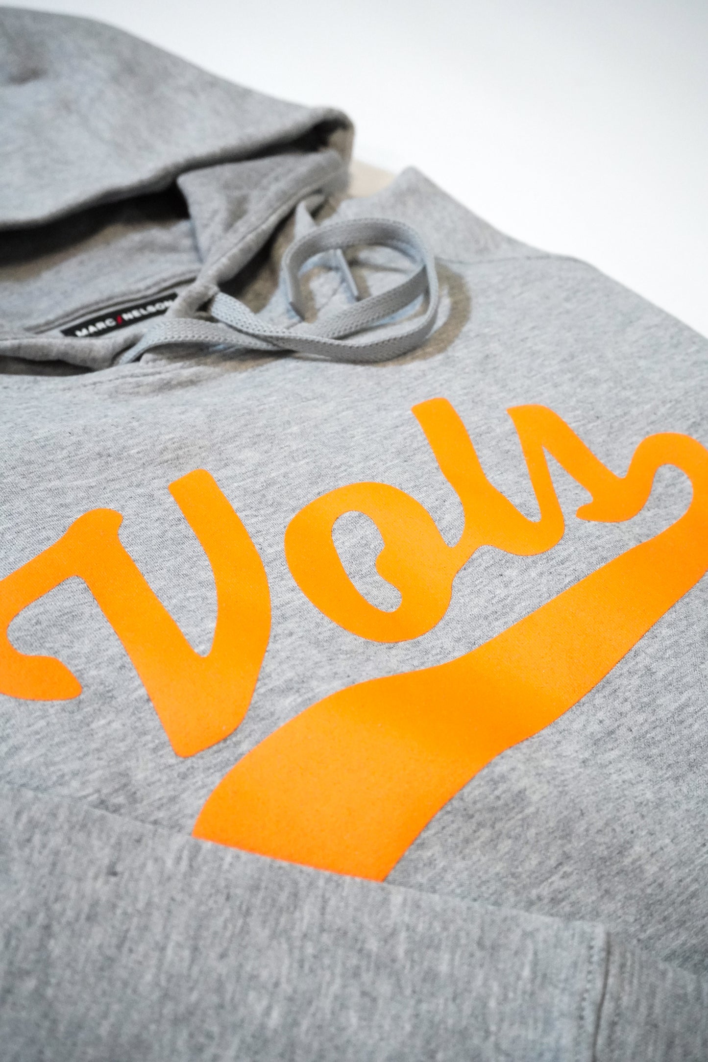 A gray hoodie with the word Vols written in bold, orange letters across the chest. The hoodie has a drawstring and a visible hood.