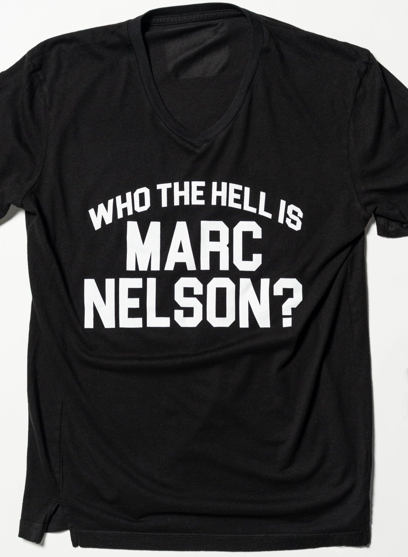 A black t-shirt with the bold, white text: WHO THE HELL IS MARC NELSON? printed on the front.