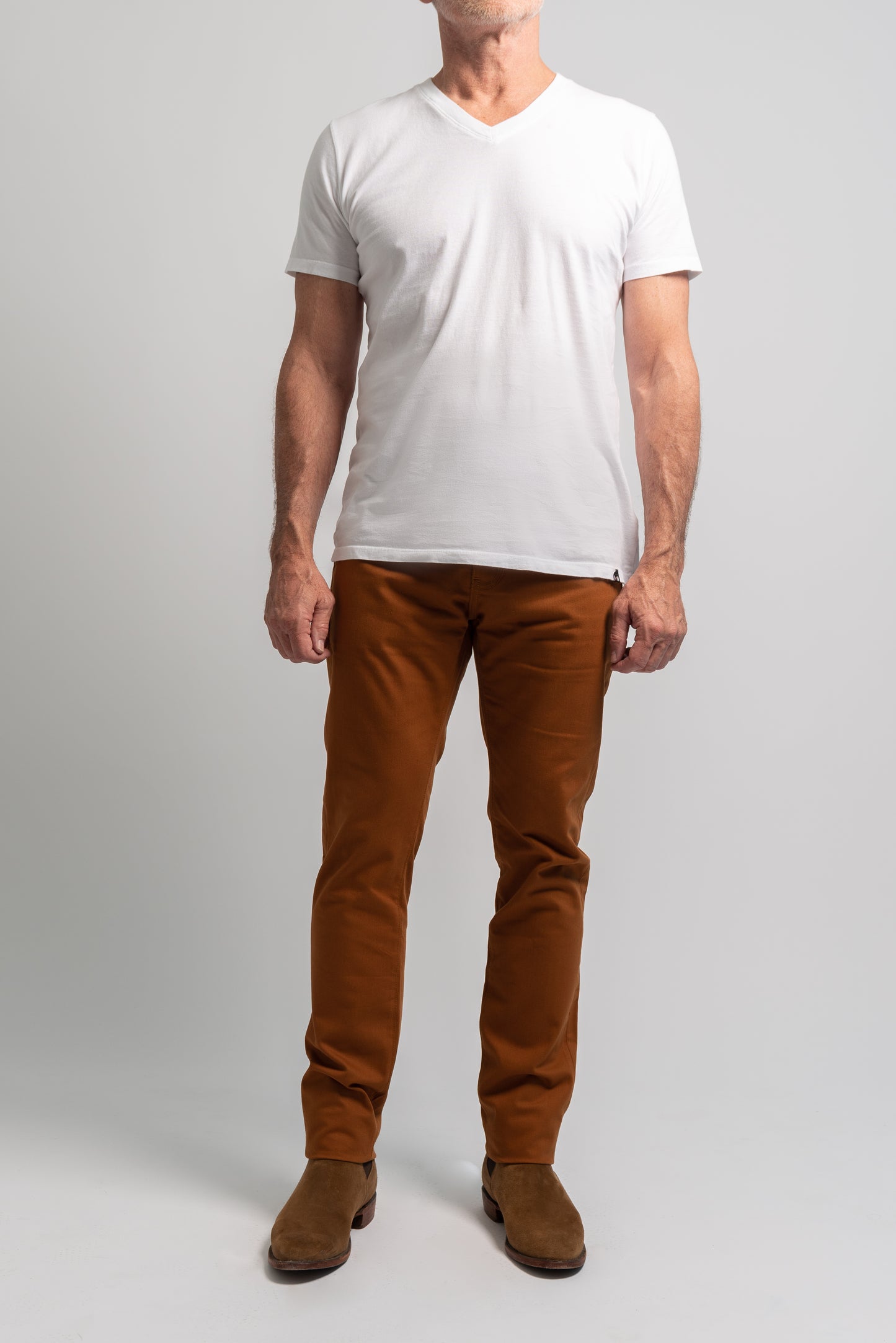Full length photo of whiskey washed denim on a model wearing a white tee shirt on a white background