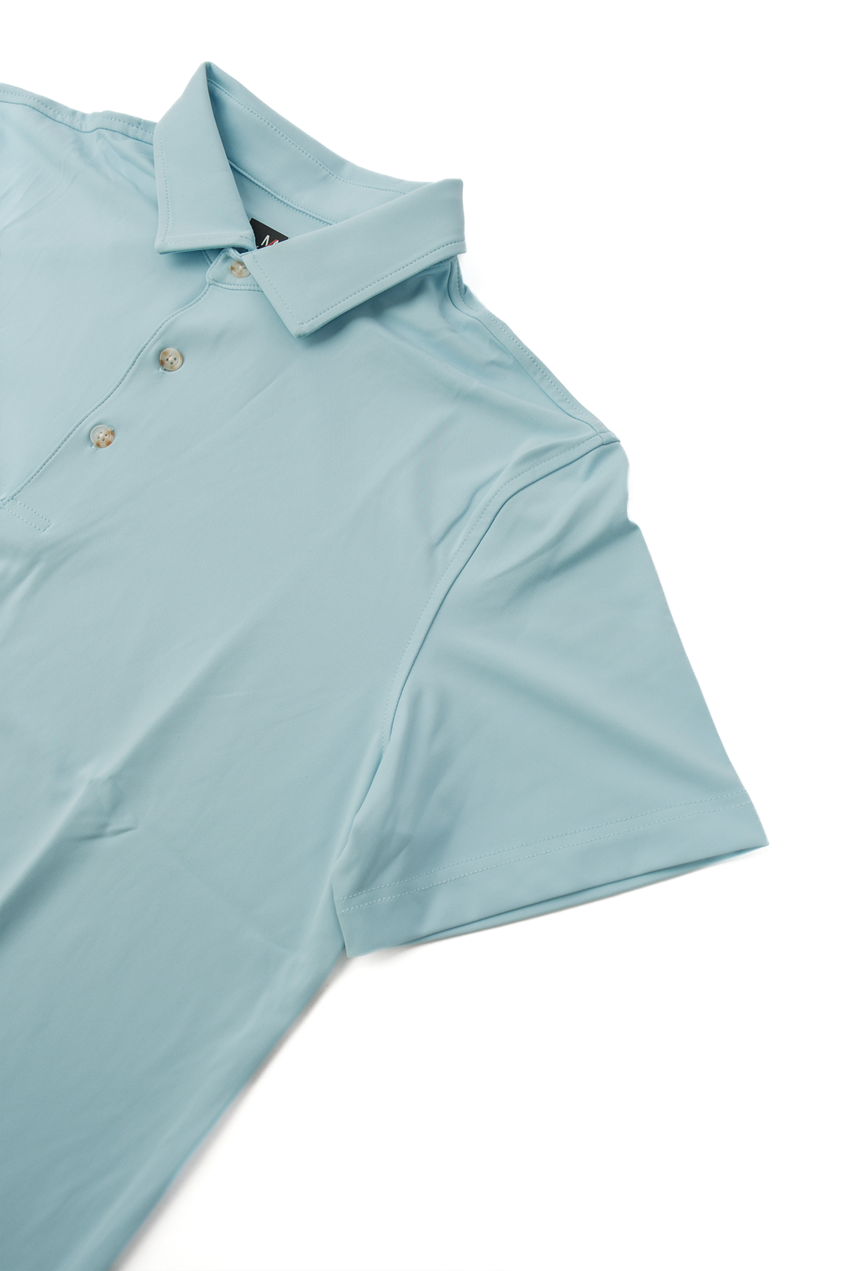 Light blue golf polo laid flat on a white background.