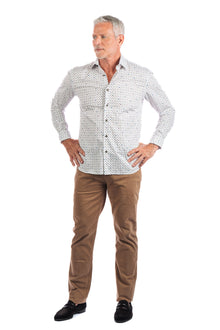  A man wearing a patterned white button up and slim straight five pocket pants in 'Buck'.
