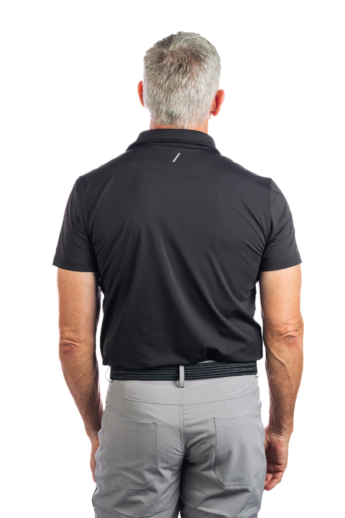 Backwards facing Photo of model wearing a black golf polo and concrete five pocket pants on a white background