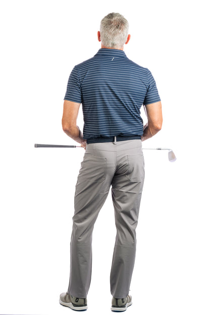 Back view of a model posing in a navy striped golf polo and grey pants, holding a golf club.