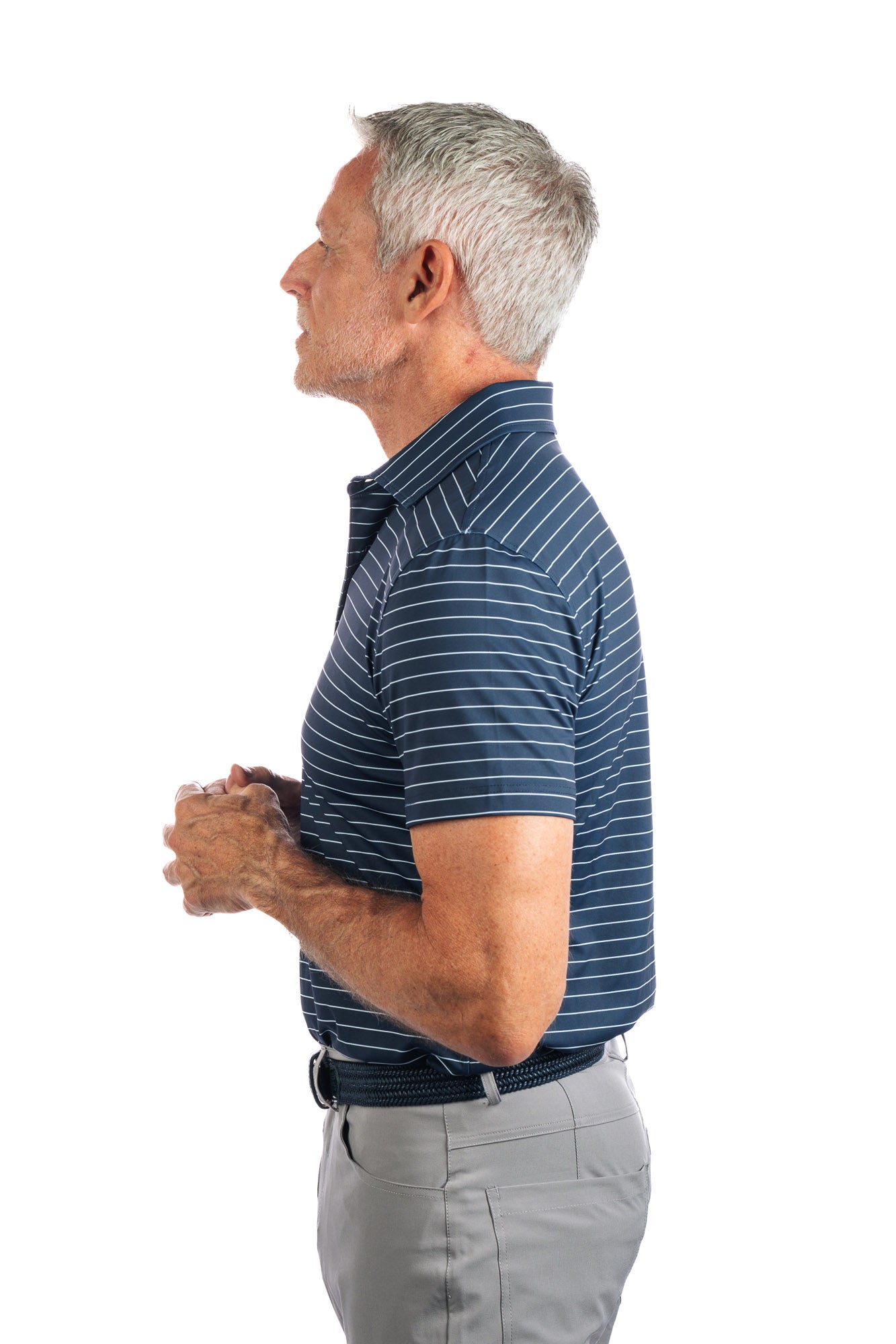 Side profile photo of model wearing navy polo with white stripes on a white background with the model looking to the left. 