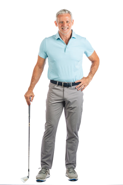 Full length body photo of model wearing light blue golf polo and concrete golf pants. 
