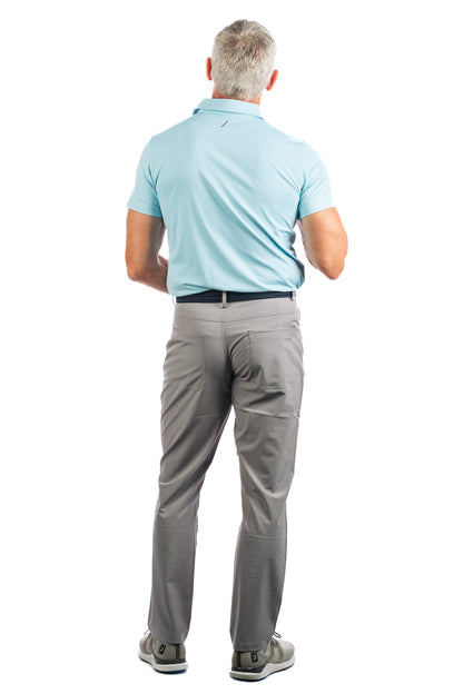Backside of model wearing light blue golf polo and concrete golf pants. 