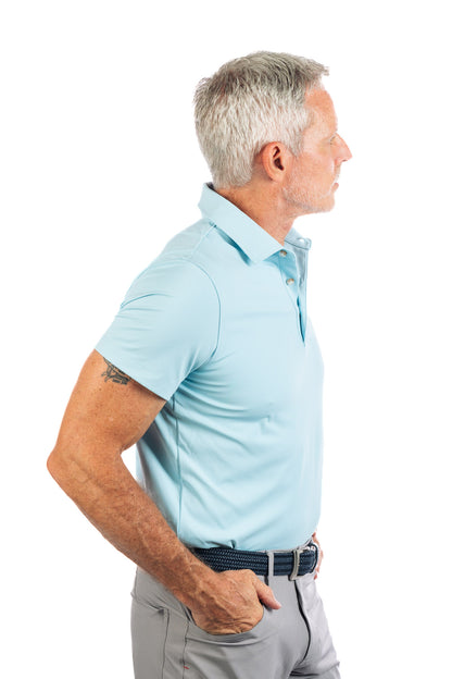 Side profile of model wearing light blue golf polo looking away from the camera. 