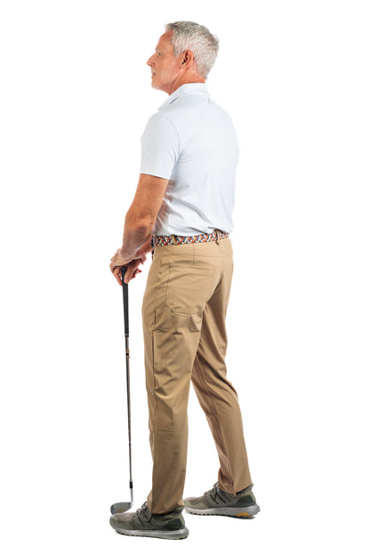 Photo of a model wearing our White Golf Polo on a White Background looking away from the camera.