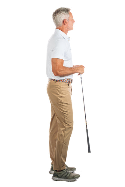 Photo of a model wearing our White Golf Polo on a White Background showing the models side profile. 