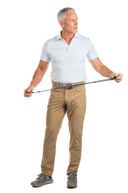 Photo of a model wearing our White Golf Polo on a White Background holding a golf club and looking to the right. 