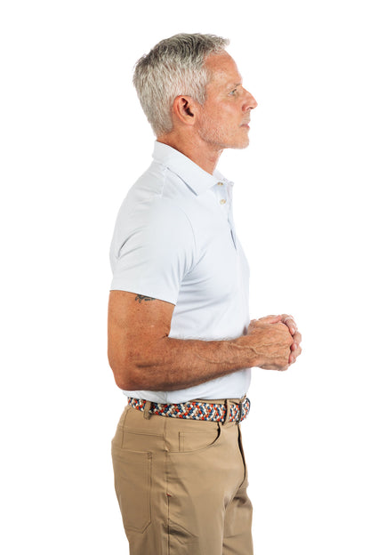 Photo of a model wearing our White Golf Polo on a White Background and the model is looking to the right. 