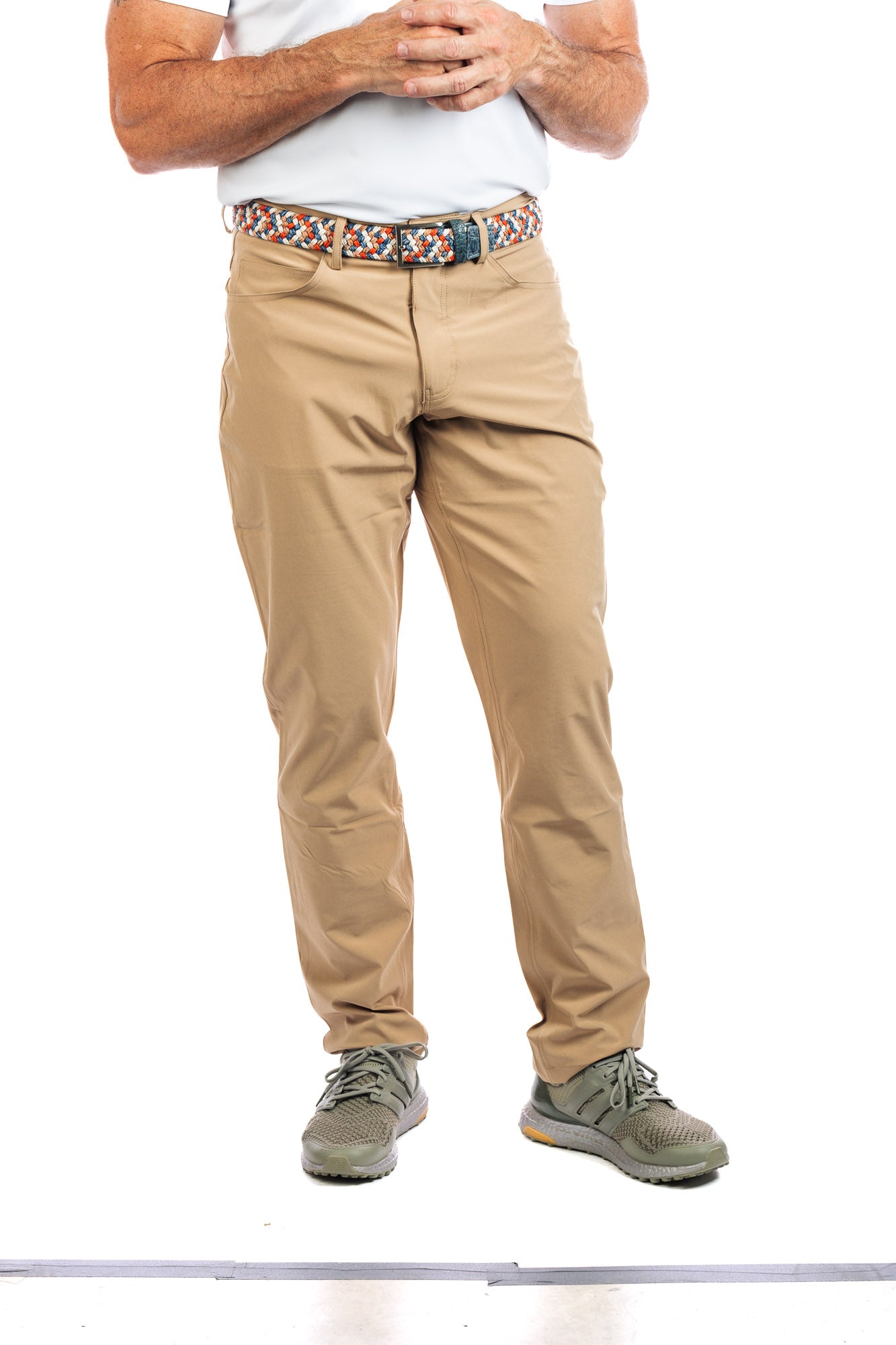 Frontal view of a male model wearing our sand golf pants. 