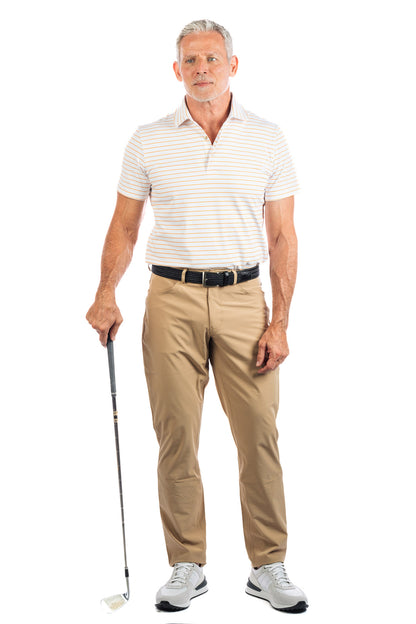 Full body shot of a male model wearing our Sand golf pants and White with orange stripe golf polo. 