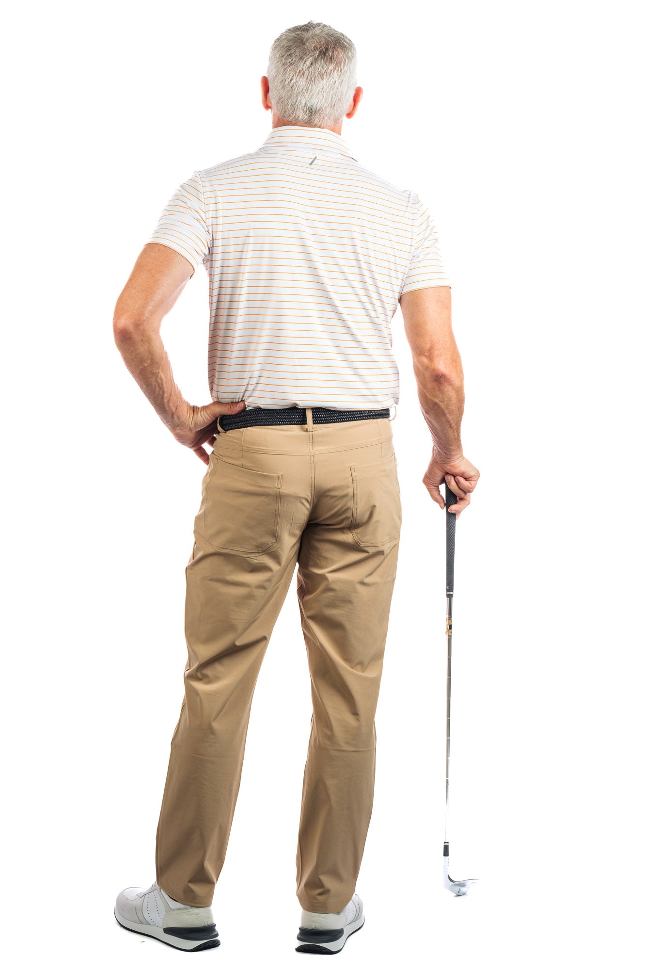 Full length photo of Model wearing Orange Striped Golf Polo on a white background showing us his back. 