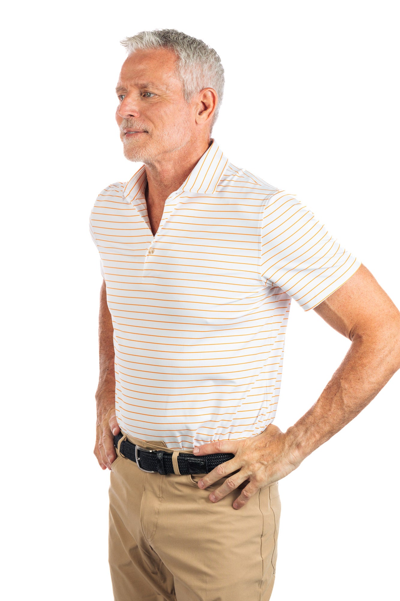 Waist up photo of model wearing the Orange striped golf polo on a white background looking to the left. 
