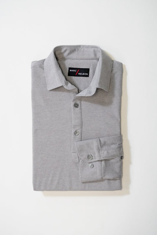 A neatly folded light gray collared shirt with buttons, displayed on a plain white background. The label inside the collar reads Marc Nelson.