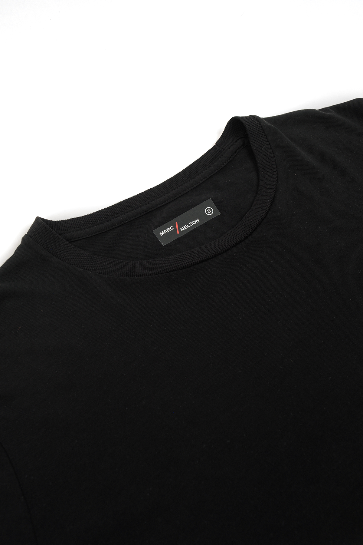 Close up of a black crew neck t-shirt laid out on a white background.