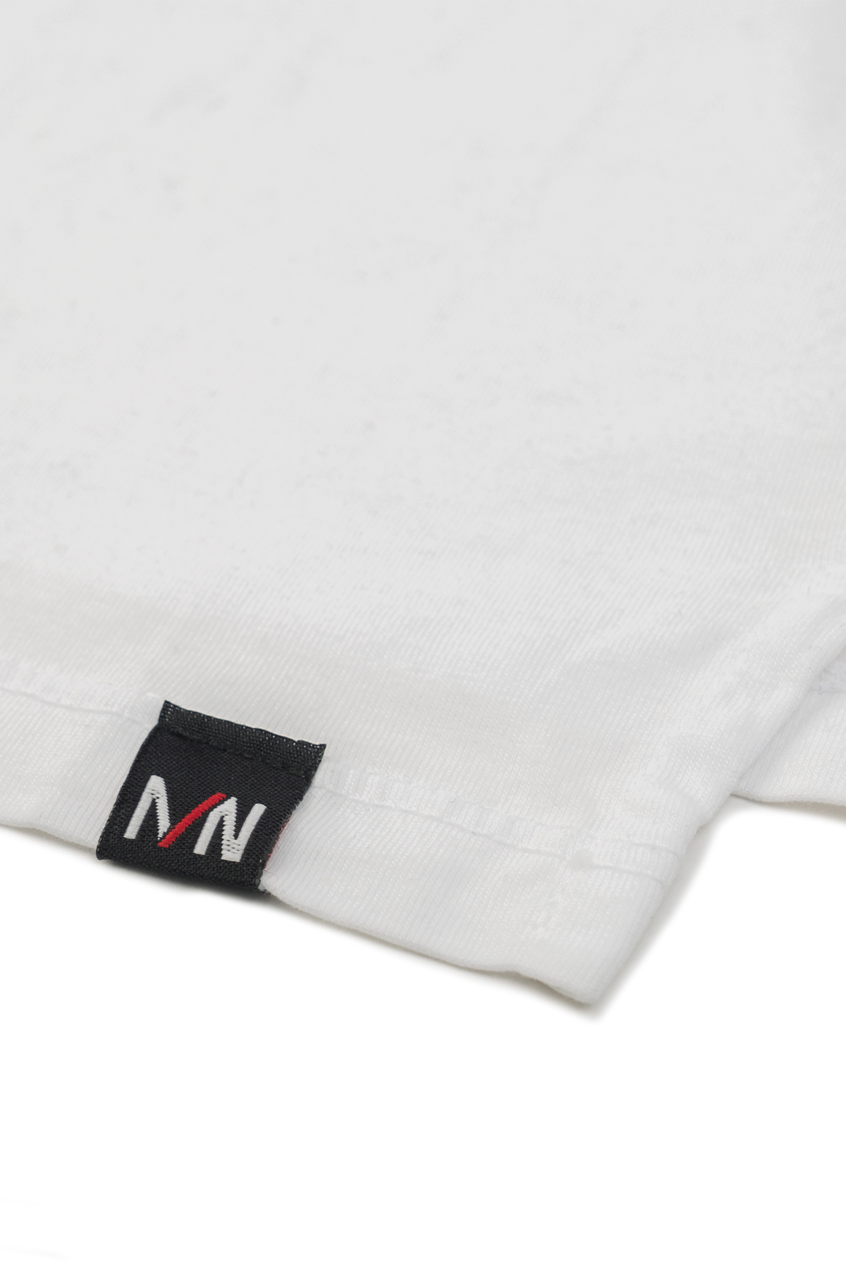 Close up shot of white crew neck t-shirt laid on a white background.