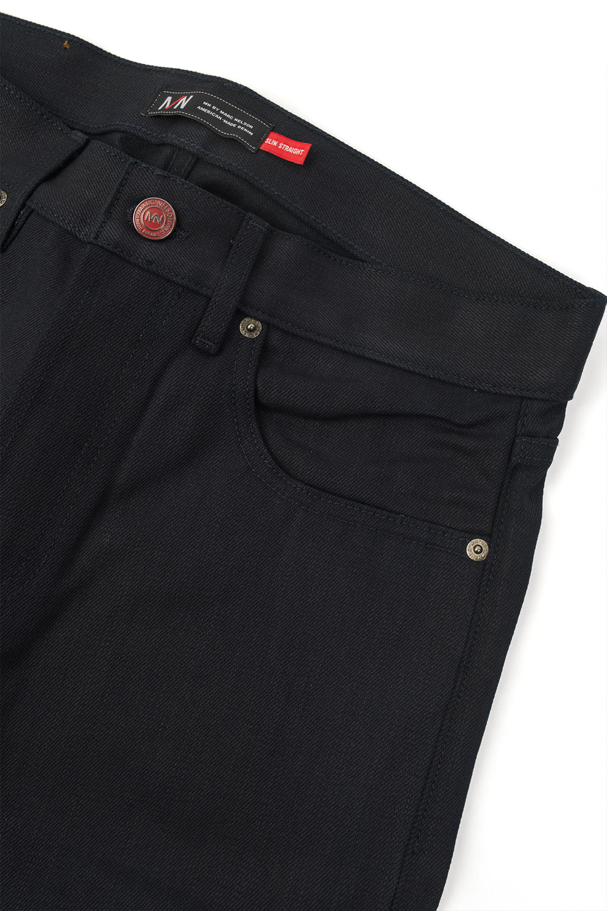 Close up photo of Kaihara blue stitch denim on white background showing the front pocket and front button. 