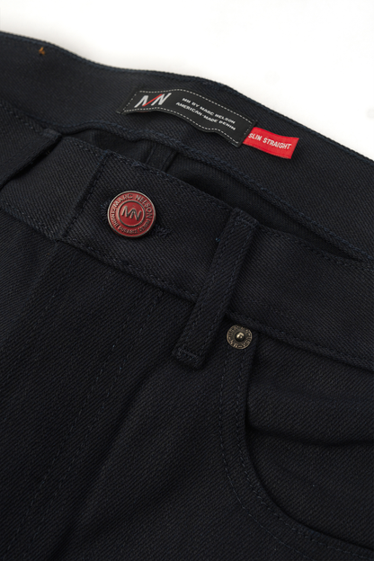 Close up photo of Kaihara blue stitch denim on white background showing the front pocket and front button.