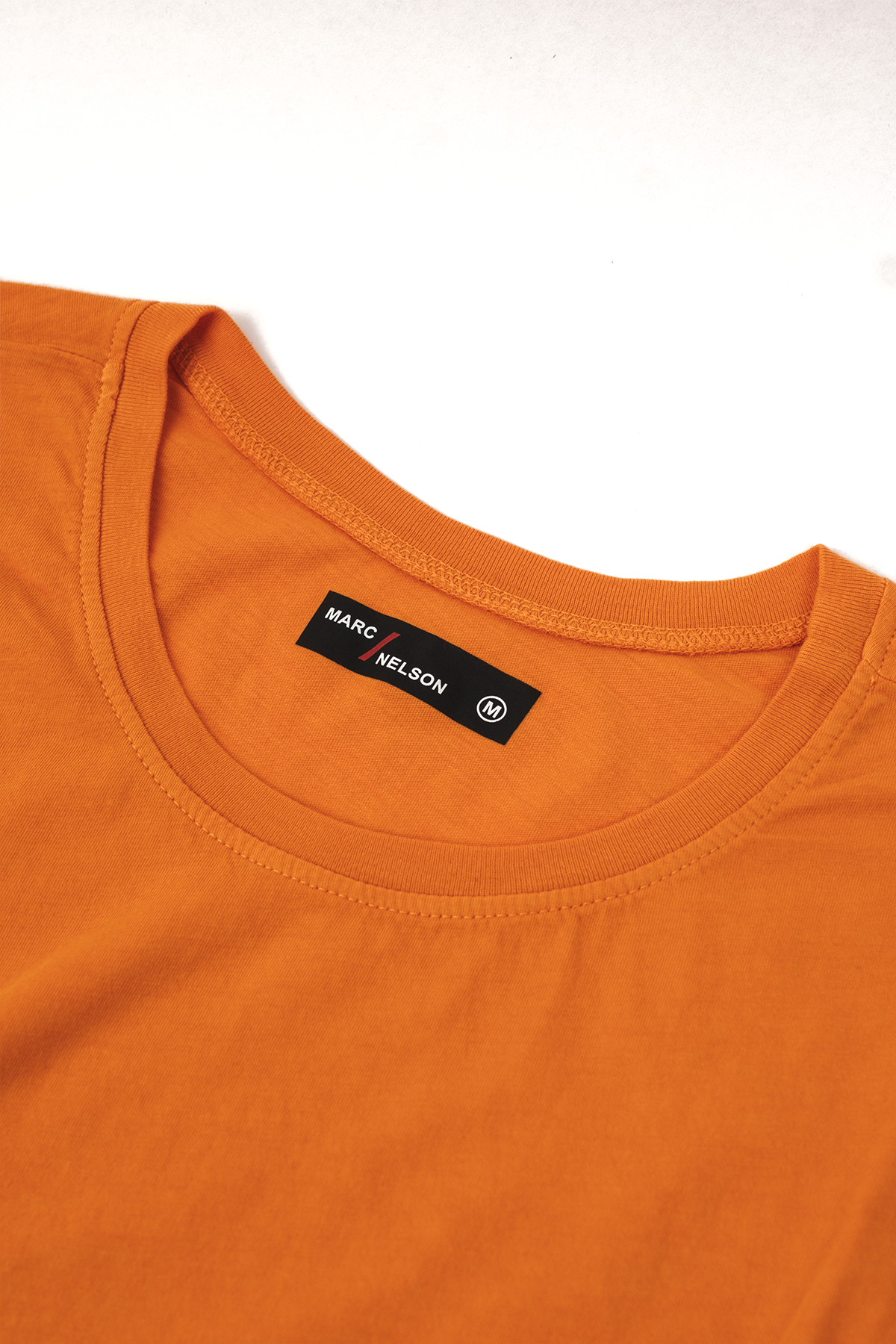 orange long sleeve crew neck shirt close up