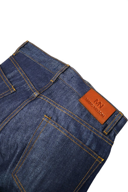 Close up photo of cone mills selvedge denim on a white background displaying the back label and back pockets. 