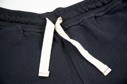 Close up photo of black lounge shorts on a white background displaying the laces. 