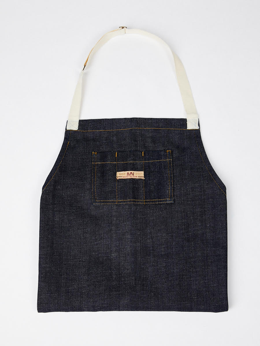 Photo of the Common Apron in Indigo folded on a white background. 