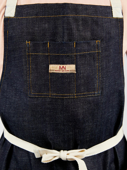 Close up photo showing the details of the common apron in indigo. 